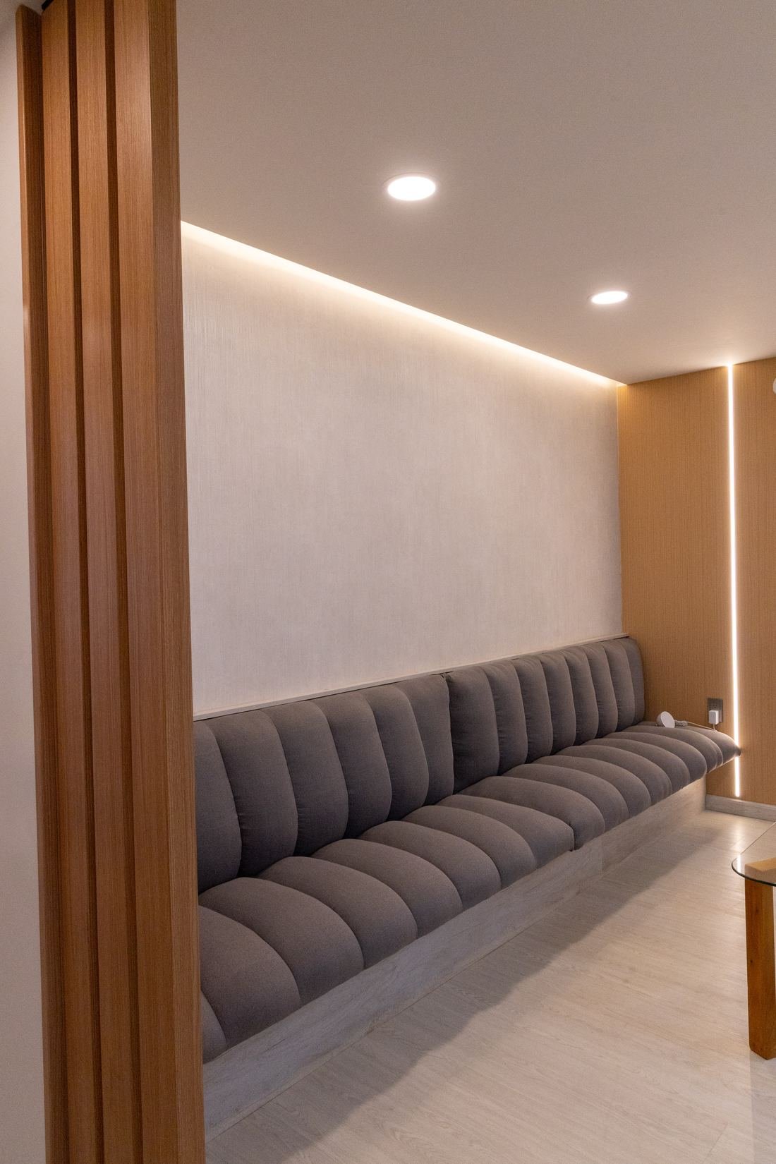 Sala de espera diseñada por Decora: banca tapizada, muro de lambrín y luz indirecta