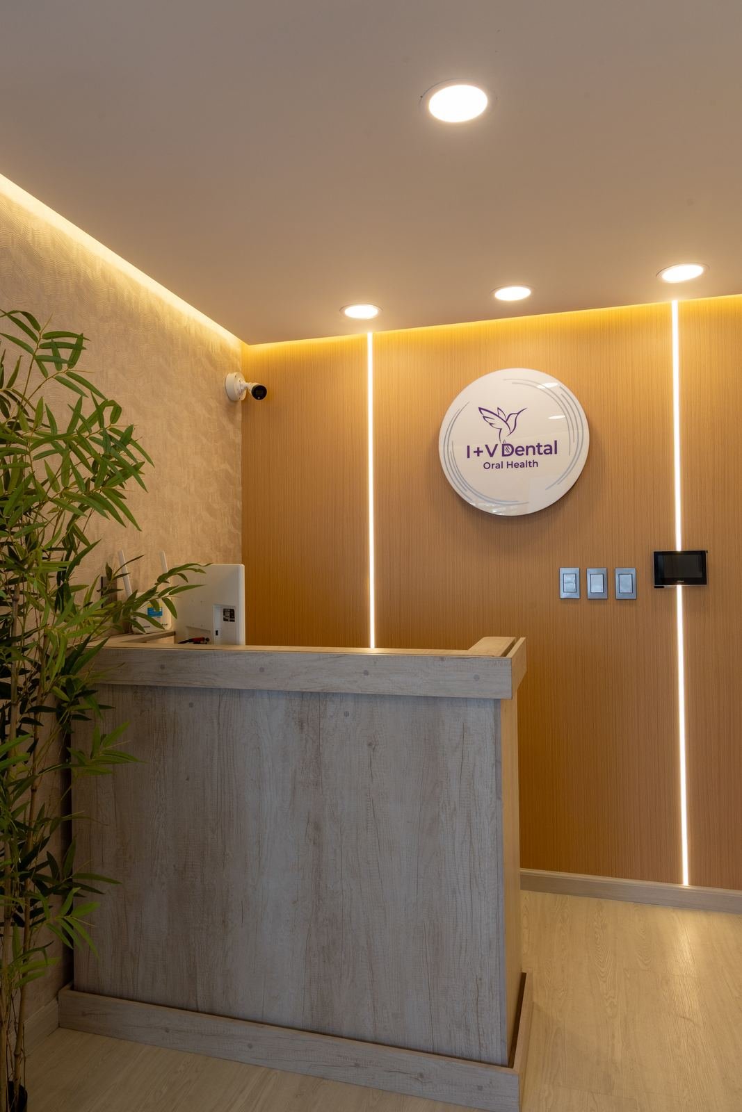Recepción con mostrador, muro de madera y líneas de luz LED