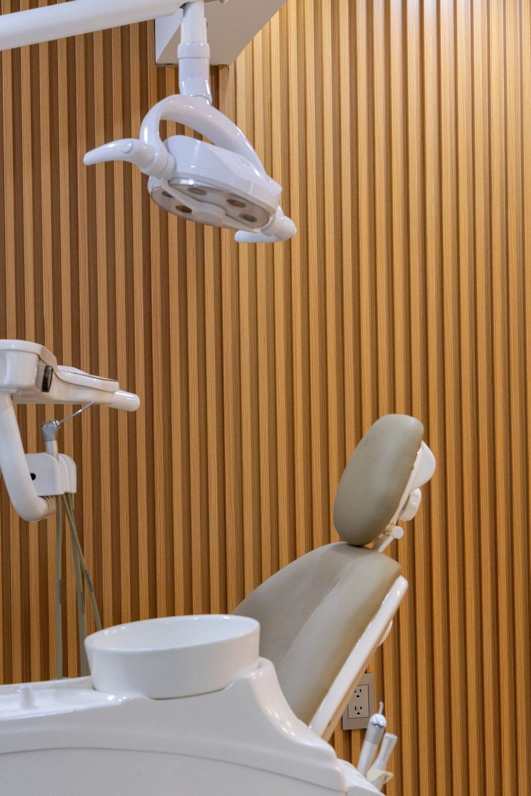 Consultorio dental: lámpara y sillón frente a muro de lambrín