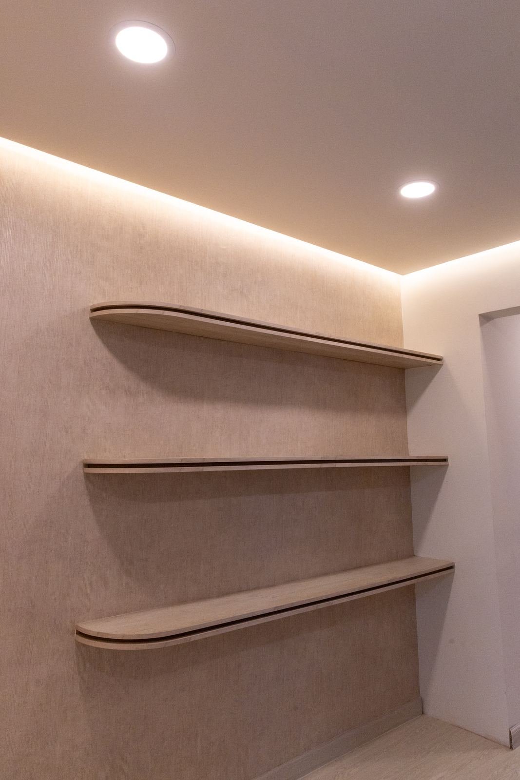 Repisas curvas sobre muro texturizado con luz indirecta