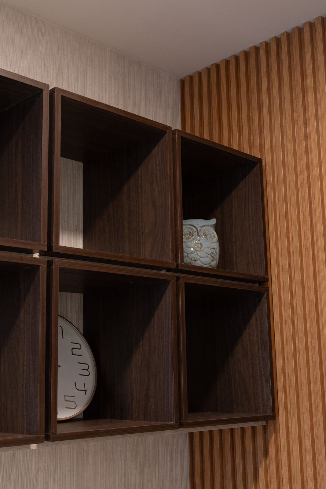 Detalle de cubos de nogal con reloj y figura decorativa