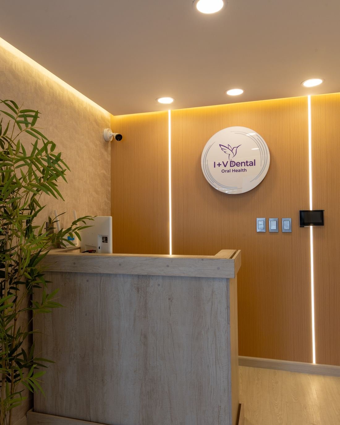 Recepción de la clínica dental en Hospital Boca del Río, con muro de madera y líneas de luz LED
