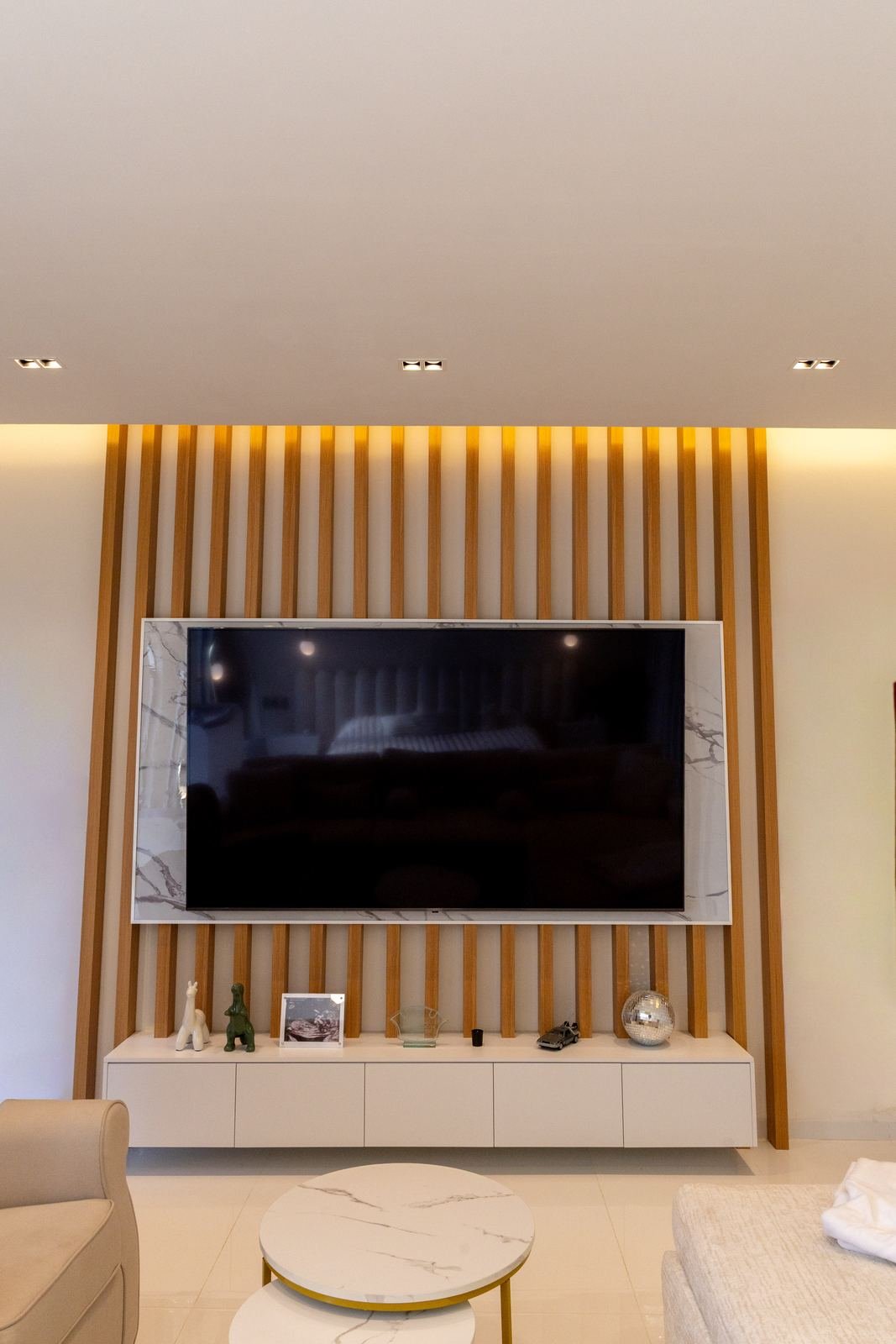 Muro de televisión con lambrín retroiluminado, marco de mármol y mueble flotante