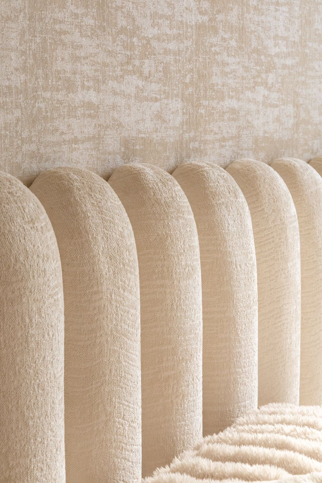 Detalle de la cabecera acanalada sobre papel tapiz texturizado