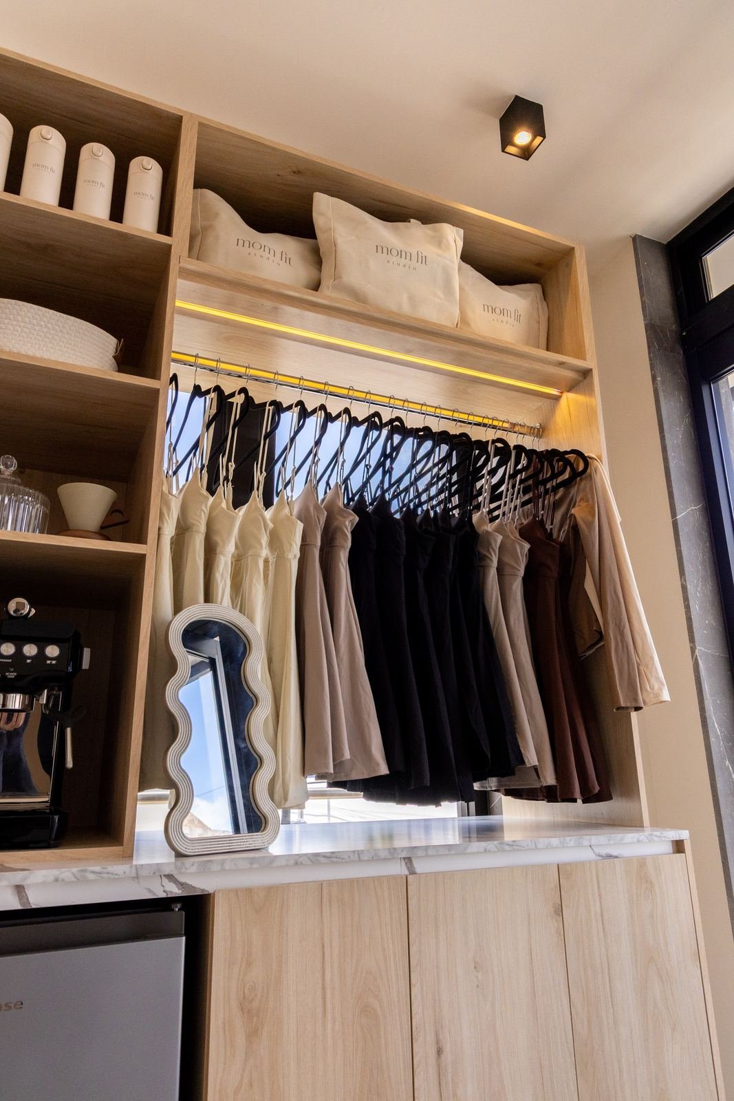 Boutique con clóset iluminado y barra de cafetera
